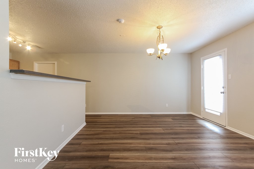 A room with wooden flooring and a chandelier.