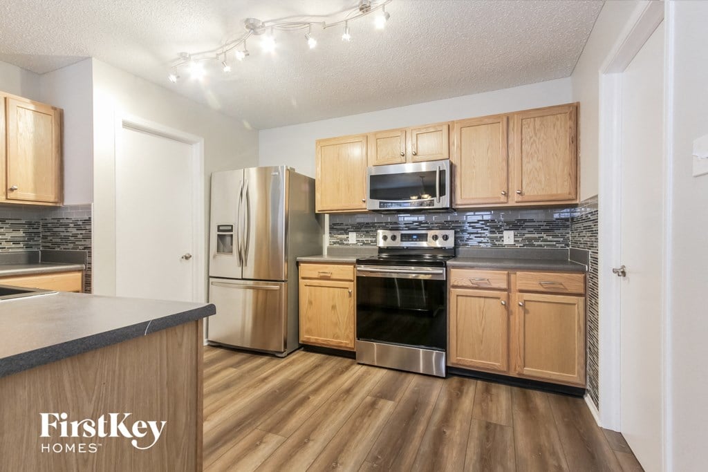 A kitchen with wooden cabinets and a black countertop.