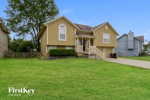 a yellow house with a yard in front of it
