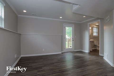 a living room with grey walls and a door to a bathroom