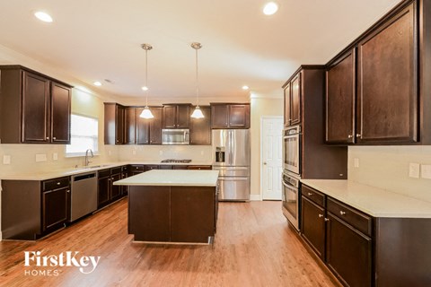 A modern kitchen with dark wood cabinets and a white countertop.