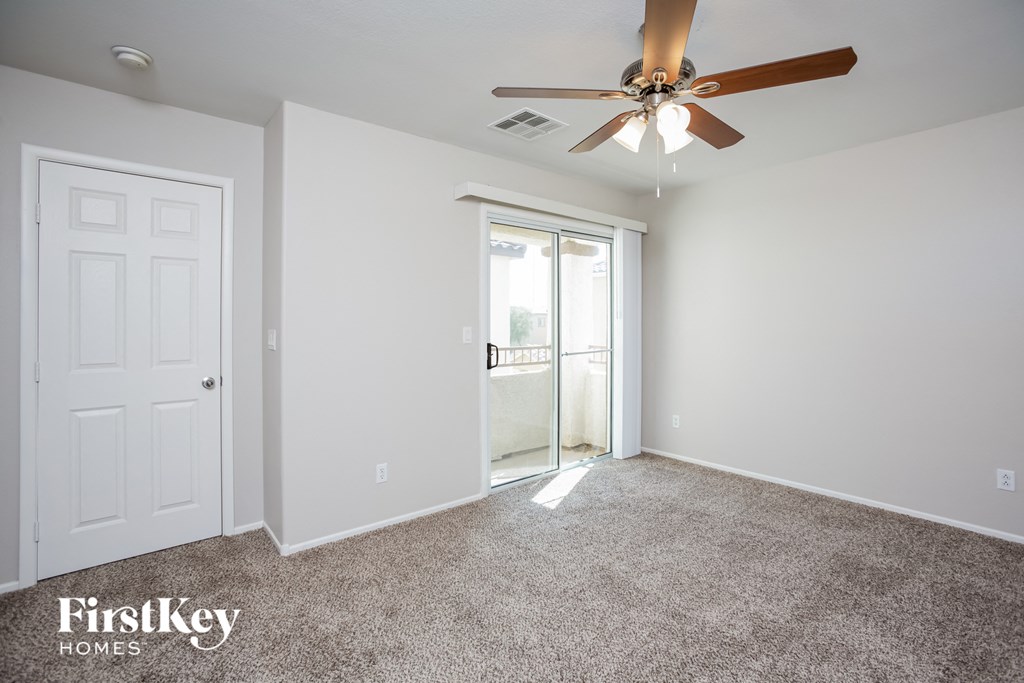 a bedroom with a ceiling fan and a door to a closet