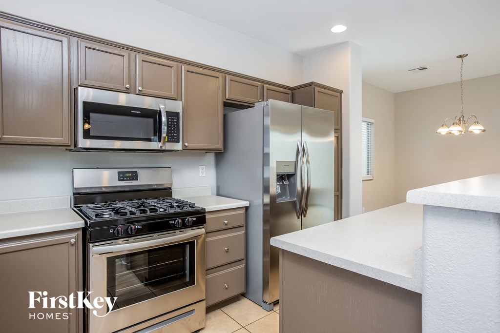 a kitchen with stainless steel appliances and white counter tops