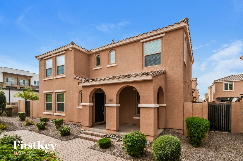 a brick house with a brick driveway and landscaping