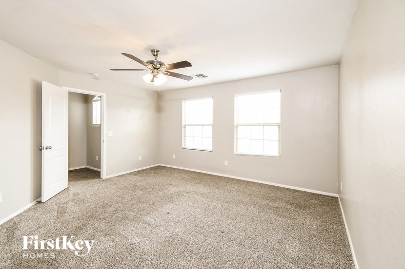 a living room with carpet and a ceiling fan