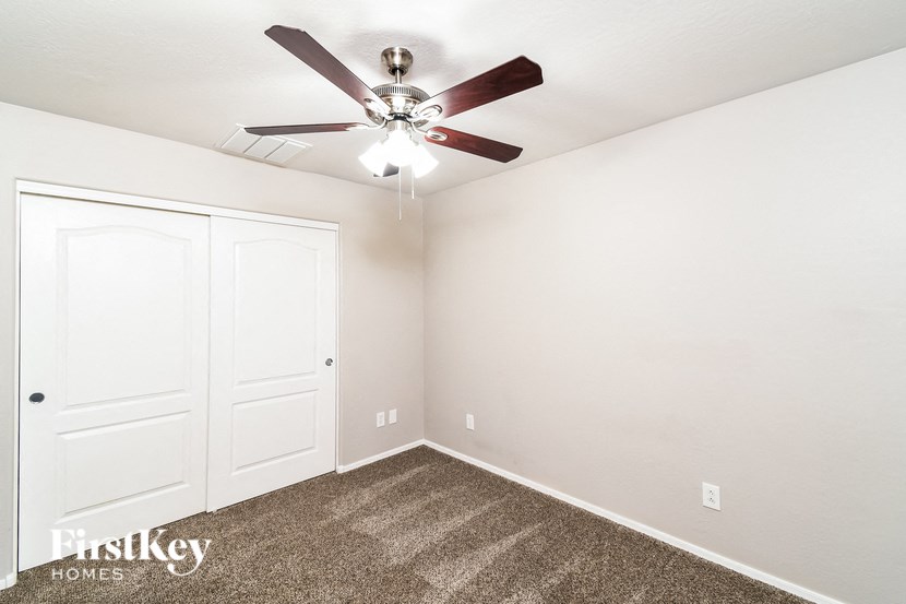 a bedroom with a ceiling fan and a closet