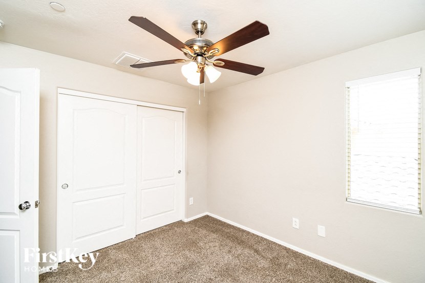 a bedroom with a ceiling fan and a closet