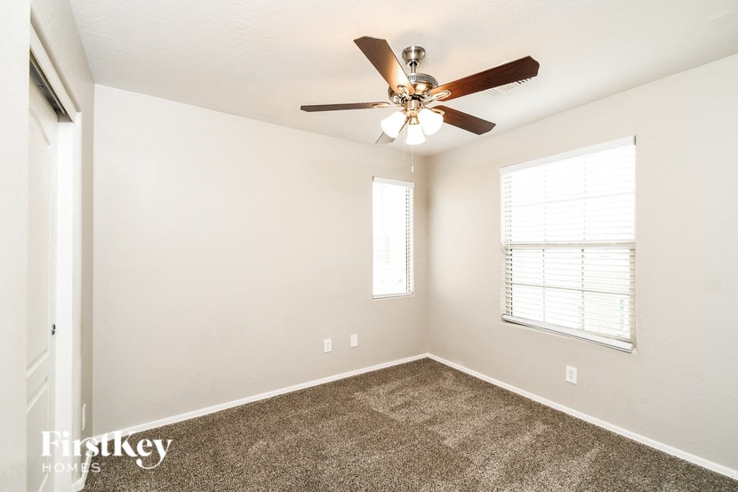 a bedroom with a ceiling fan and a window