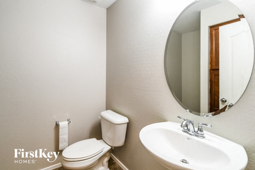 a bathroom with a sink toilet and a mirror