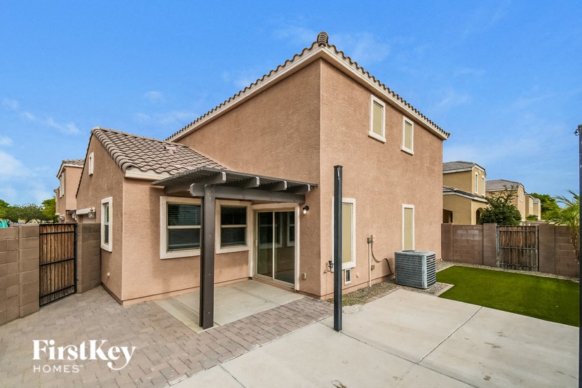 a small brick house with a driveway and a patio