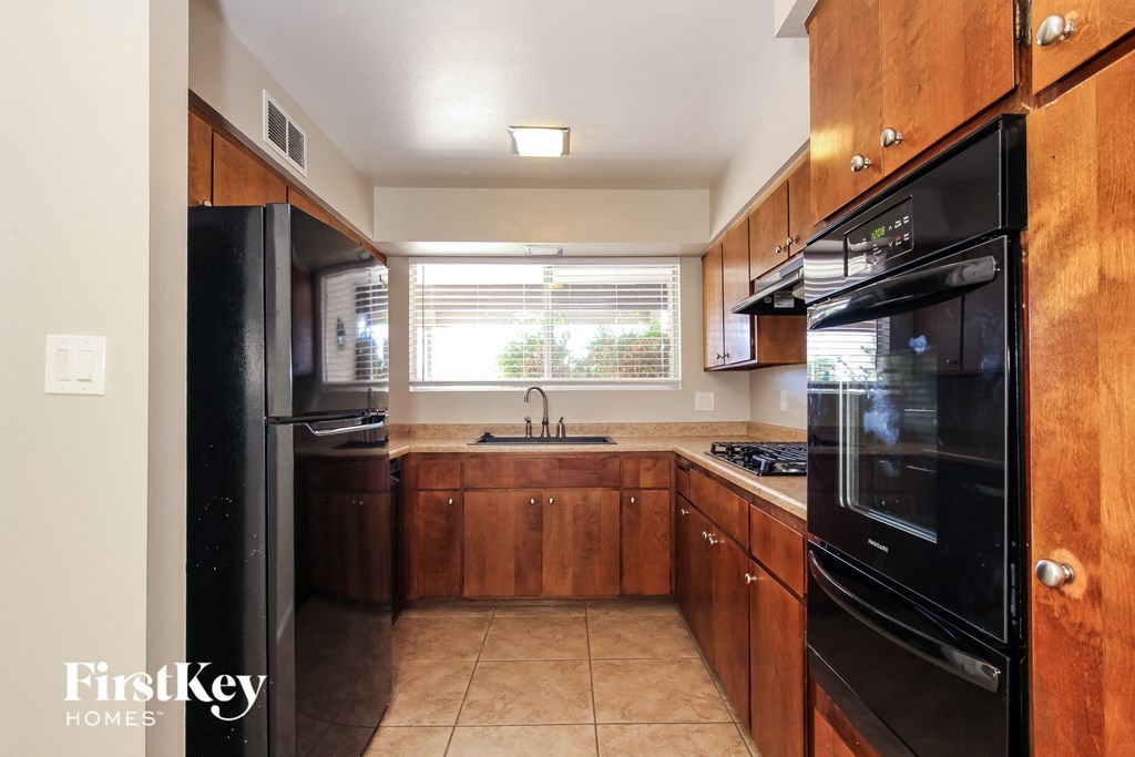 A kitchen with wooden cabinets and black appliances.
