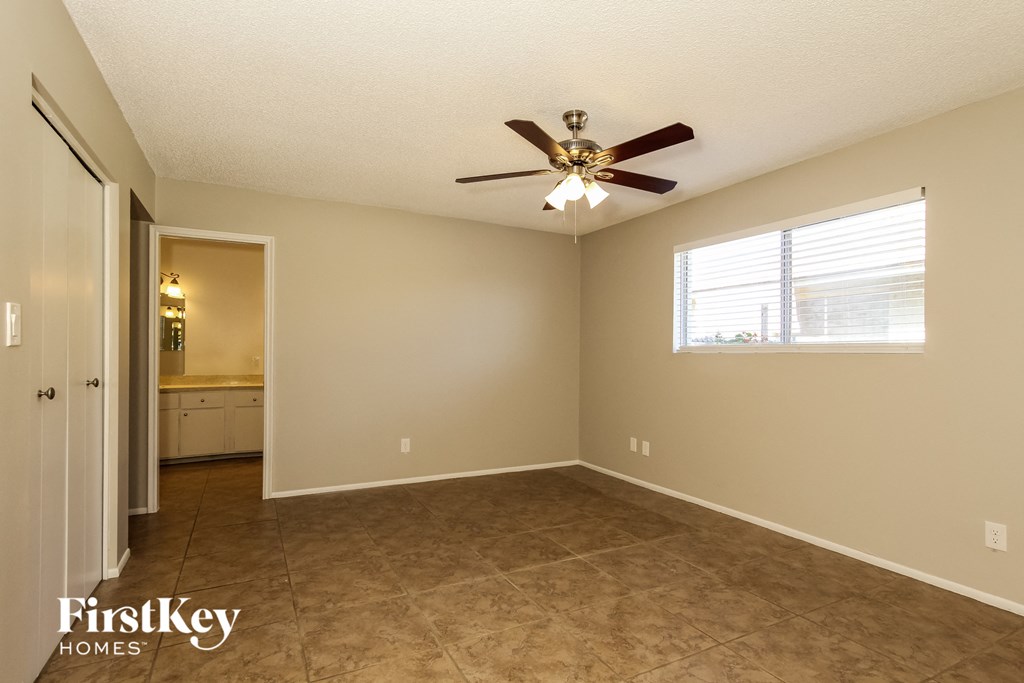 A room with a ceiling fan and a window.