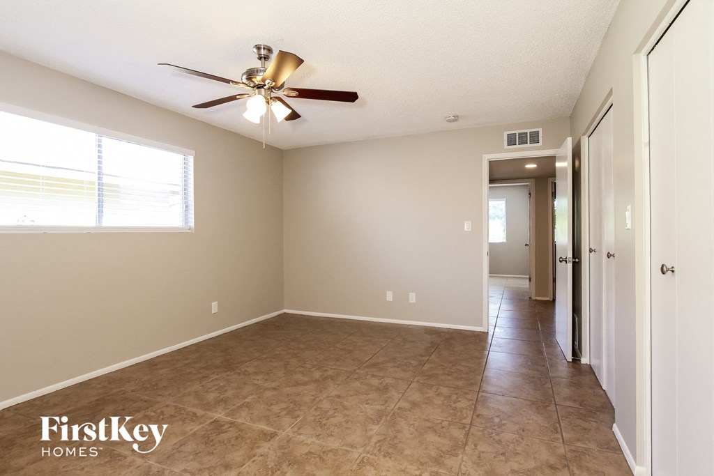 A room with a ceiling fan and a window.