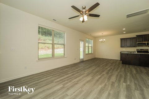 A spacious room with a ceiling fan and wooden flooring.