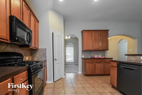 A kitchen with wooden cabinets and black appliances.