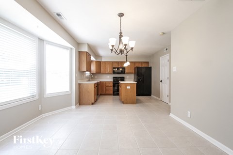 A well-lit, spacious kitchen with a chandelier hanging from the ceiling.