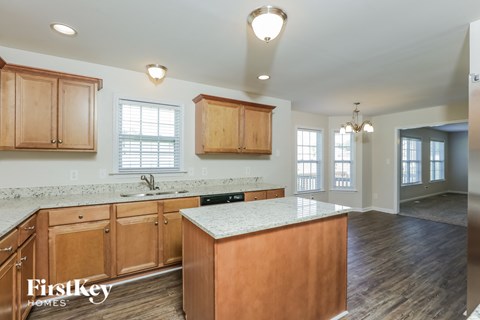 A kitchen with wooden cabinets and a marble countertop.