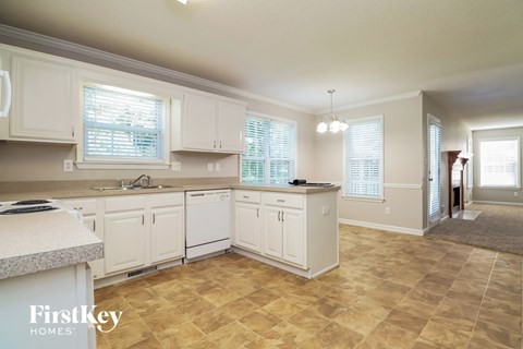 A kitchen with white cabinets and a tiled floor.
