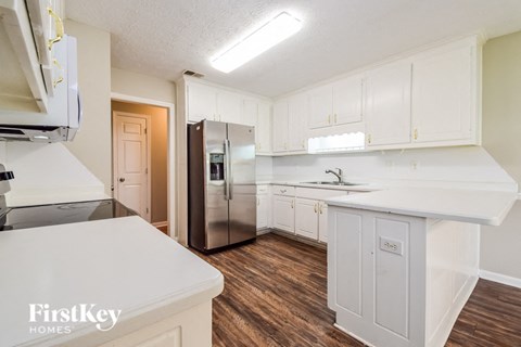 a kitchen with white cabinets and a stainless steel refrigerator