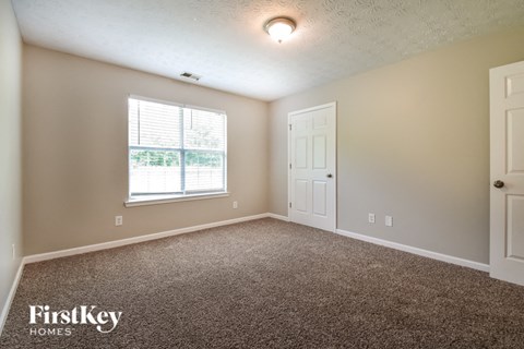 the living room of a home with carpet and a window