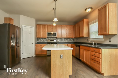 A kitchen with wooden cabinets and a black refrigerator.