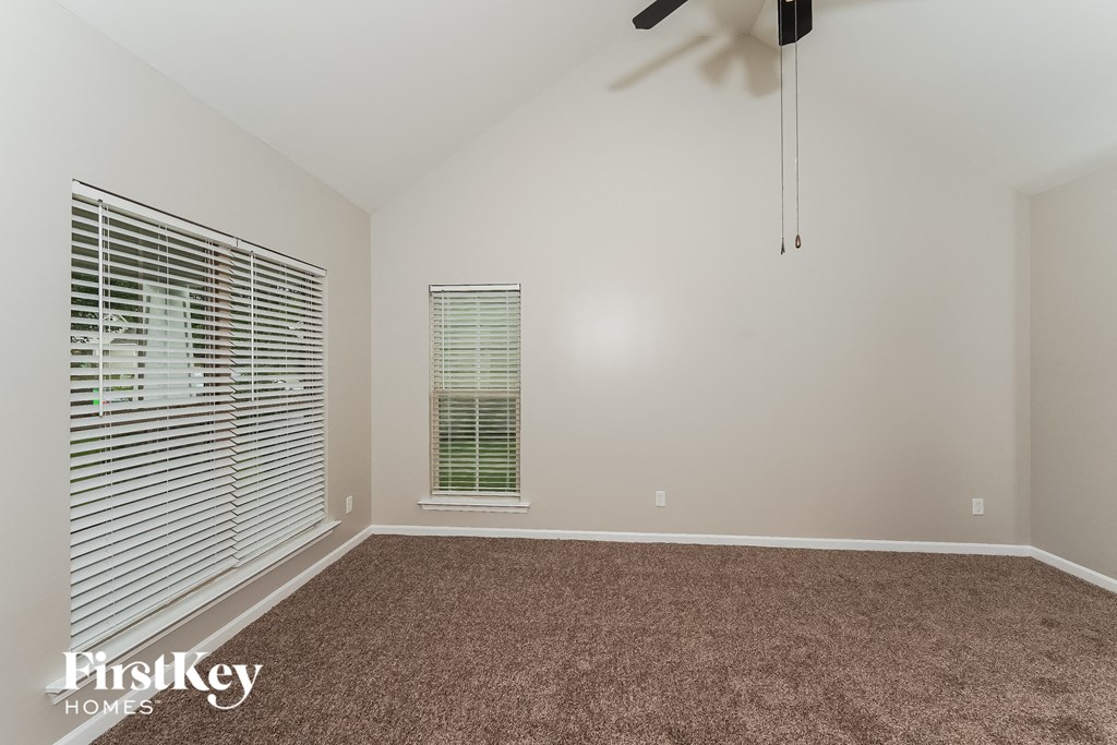a room with carpet and a window and a ceiling fan