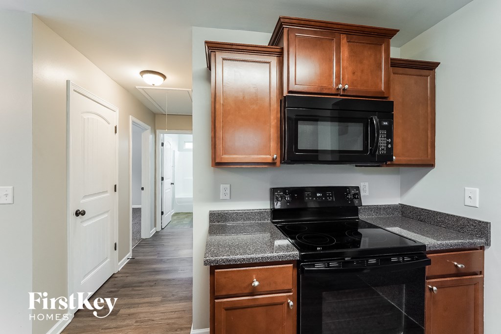 a kitchen with wood cabinets and a black stove and a microwave