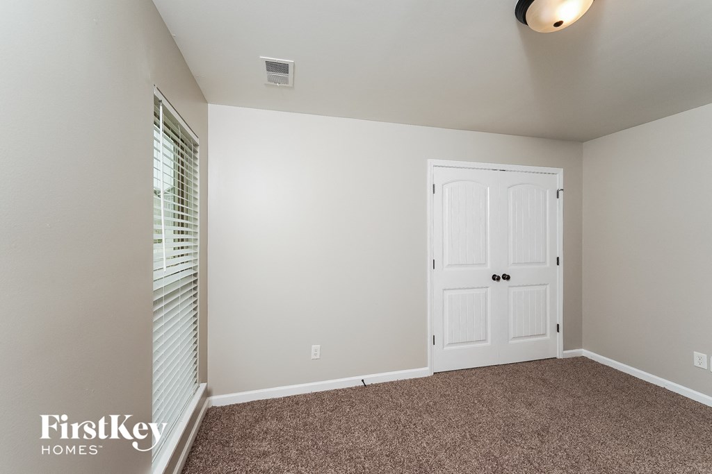a bedroom with a carpeted floor and a white door