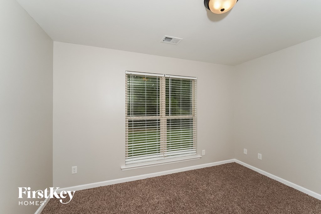 the living room of a house with a window and carpet