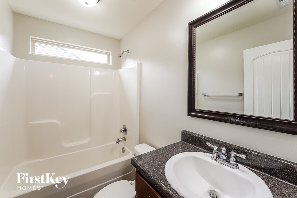 a bathroom with a sink and a bath tub and a mirror