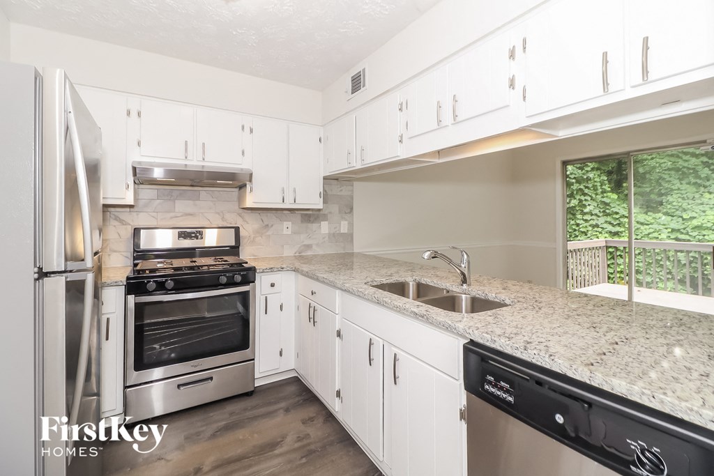 A kitchen with a stove top oven and a refrigerator.