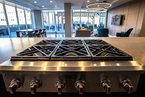 a large stove in the center of a room with a table and chairs