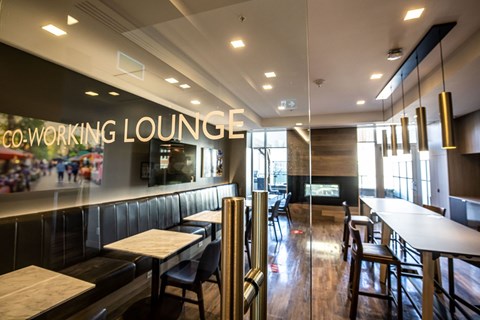 a dining area with tables and chairs and a glass wall with the words working lounge