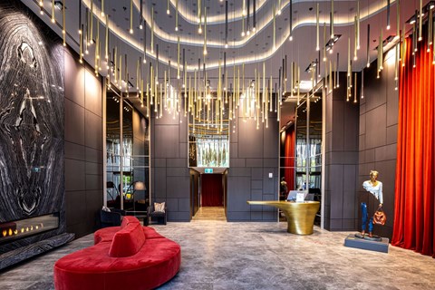 a large lobby with a red couch and a gold fountain