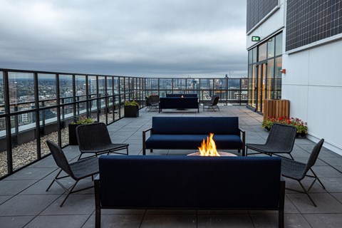 a terrace with couches and chairs and a fire pit