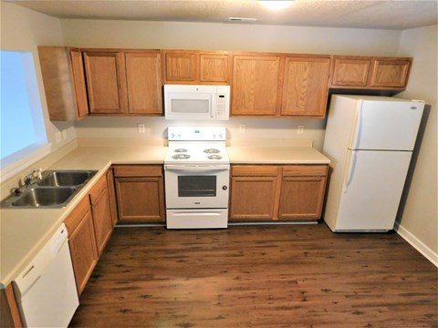 A kitchen with wooden cabinets and white appliances.