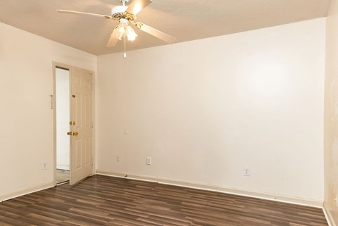 an empty room with white walls and a ceiling fan
