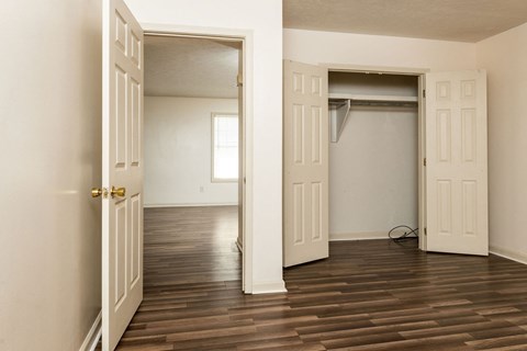 an empty room with a closet and a hard wood floor