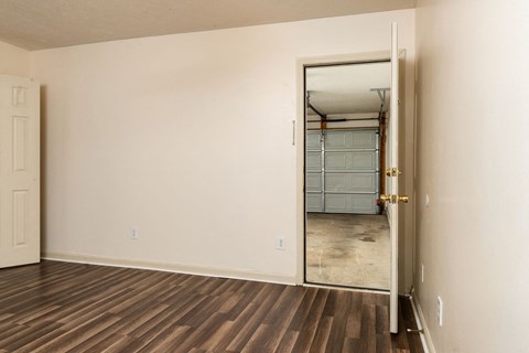 an empty living room with a door to a closet