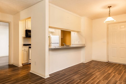 a living room with a kitchen and a hard wood floor