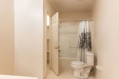 a bathroom with a toilet and a shower with a shower curtain
