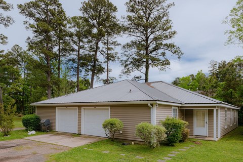 a small tan house with white garage doors