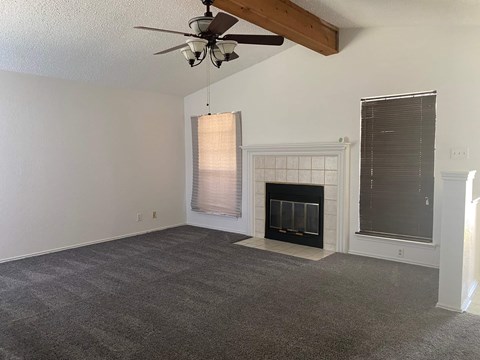 A room with a fireplace and a ceiling fan.