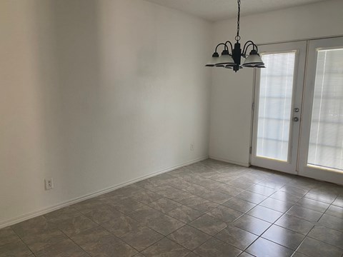 A room with a tiled floor and a hanging light fixture.