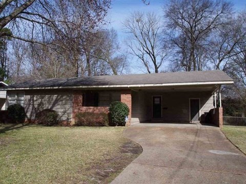 a brick house with a driveway in front of it