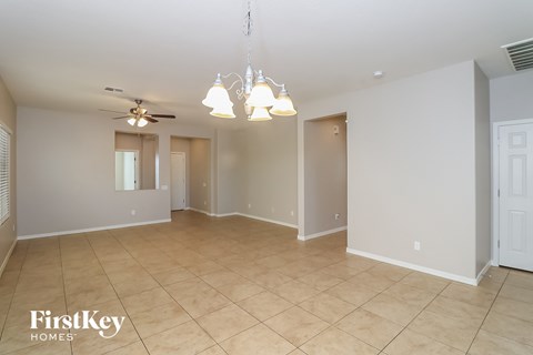A spacious room with a ceiling fan and a chandelier.