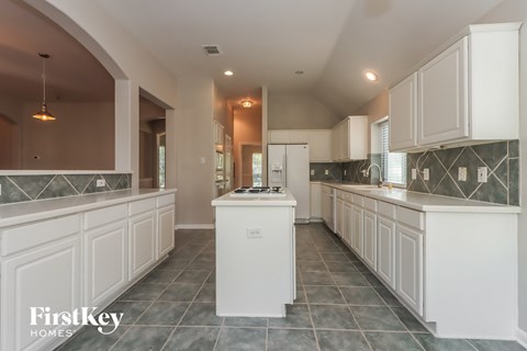 A kitchen with white cabinets and a central island.
