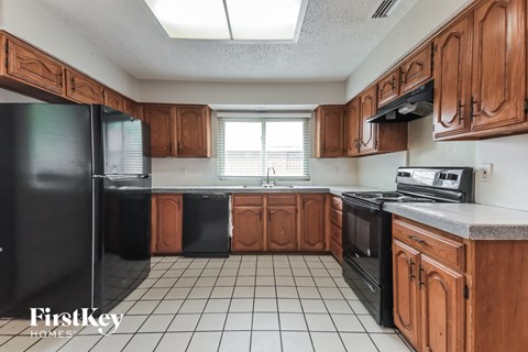 A kitchen with wooden cabinets and black appliances.
