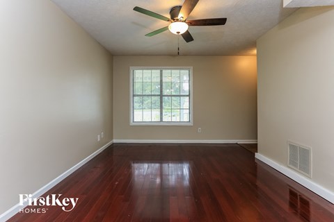 the living room with hardwood floors and a ceiling fan