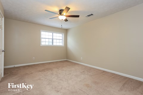 a bedroom with carpet and a ceiling fan